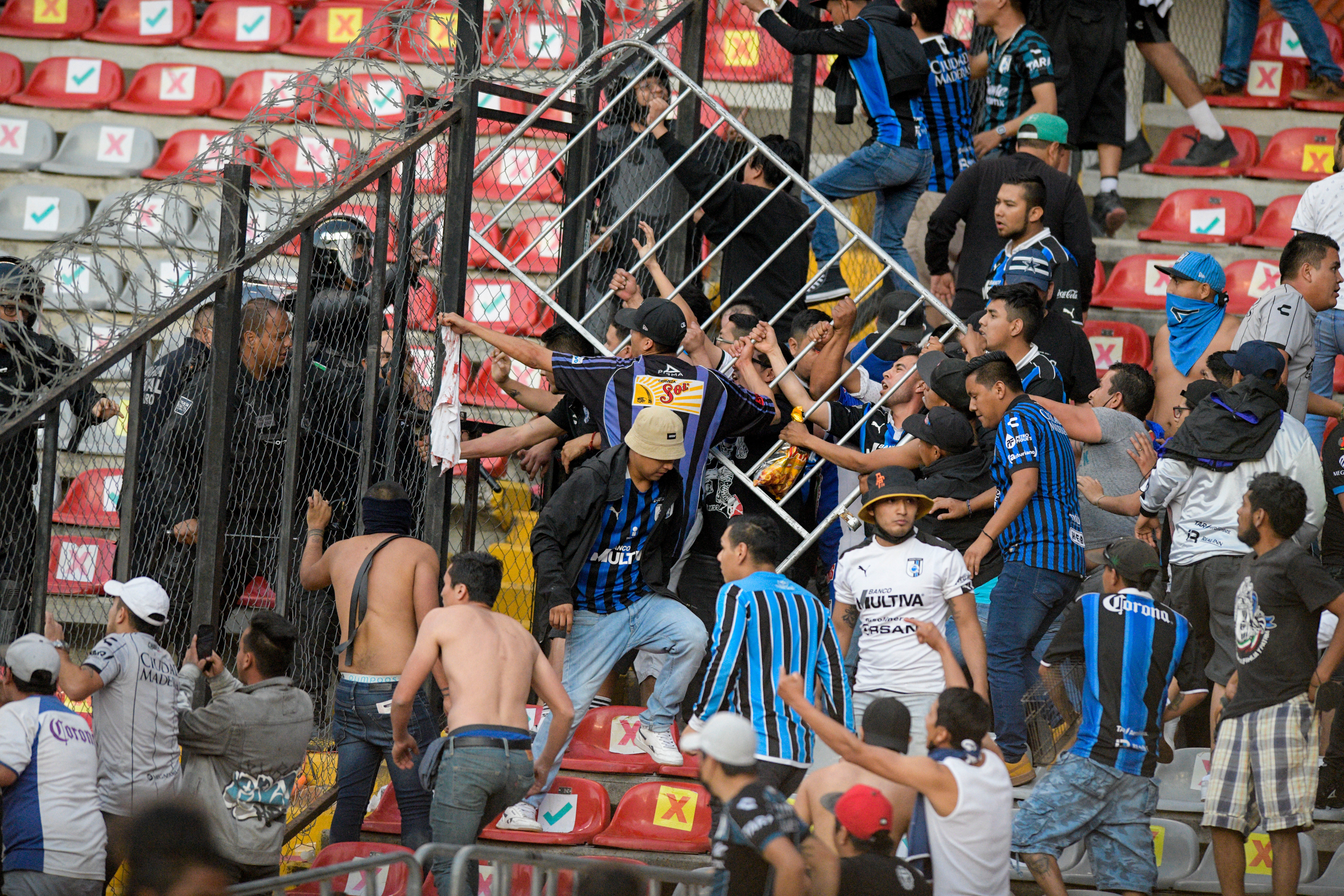 Fans clash during the match between Queretaro and Atlas (Sergio Gonzalez/AP)