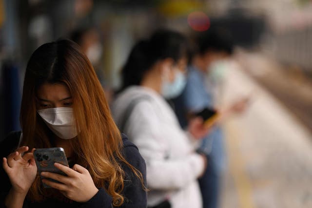 <p>People wear masks on a train platform in Hong Kong</p>