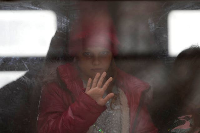 <p>A young girl fleeing the war in Ukraine looks out of the window as her train arrives in Przemysl, Poland</p>