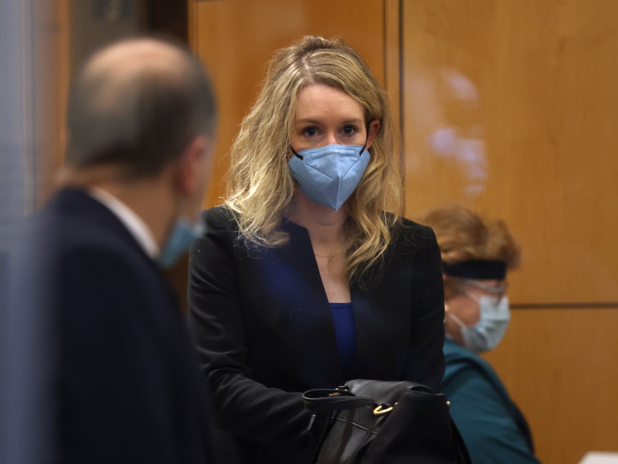 Elizabeth Holmes wears a black blazer and blue top during her trial in December - but no sign of a turtleneck