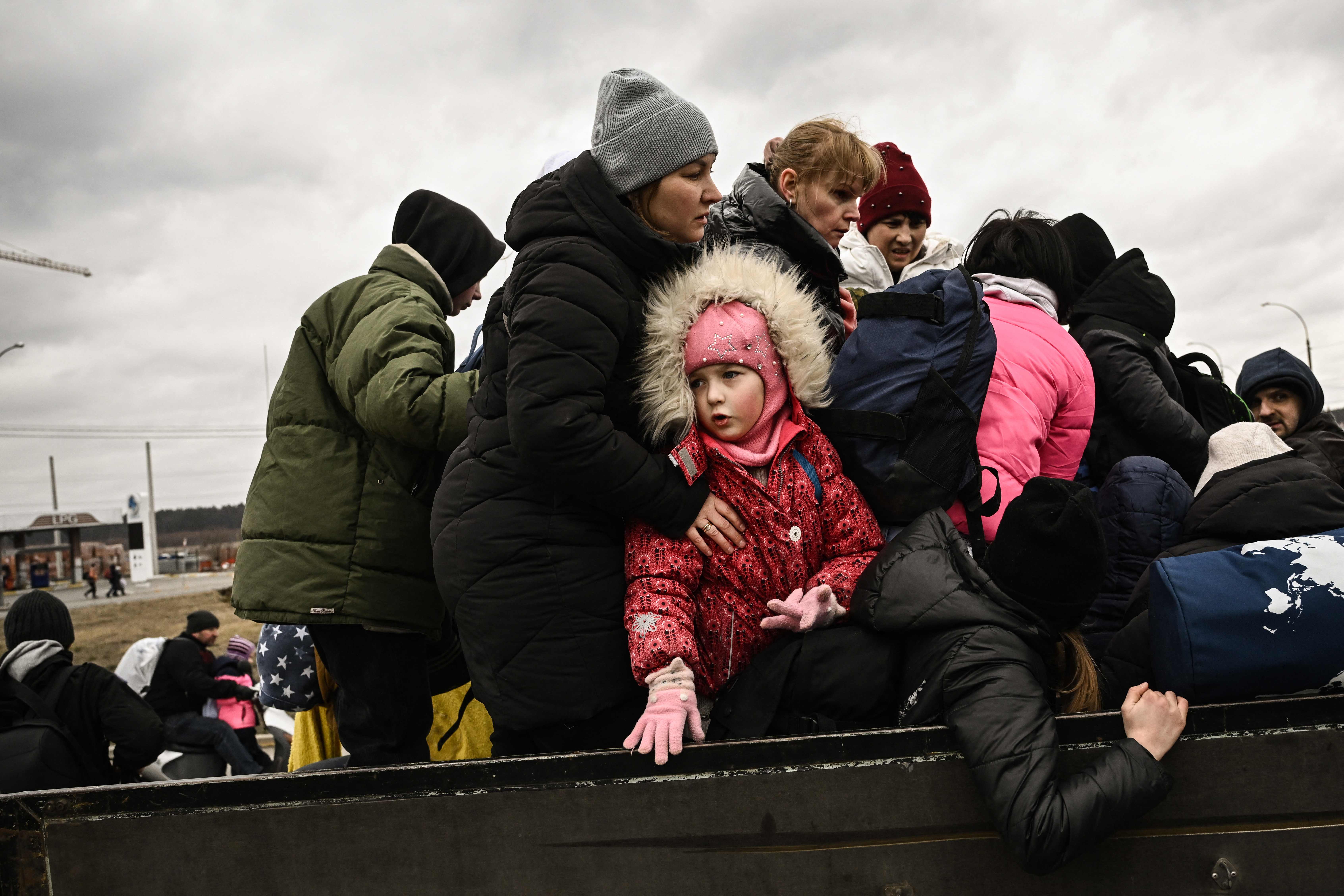 A child looks on as residents evacuate Irpin
