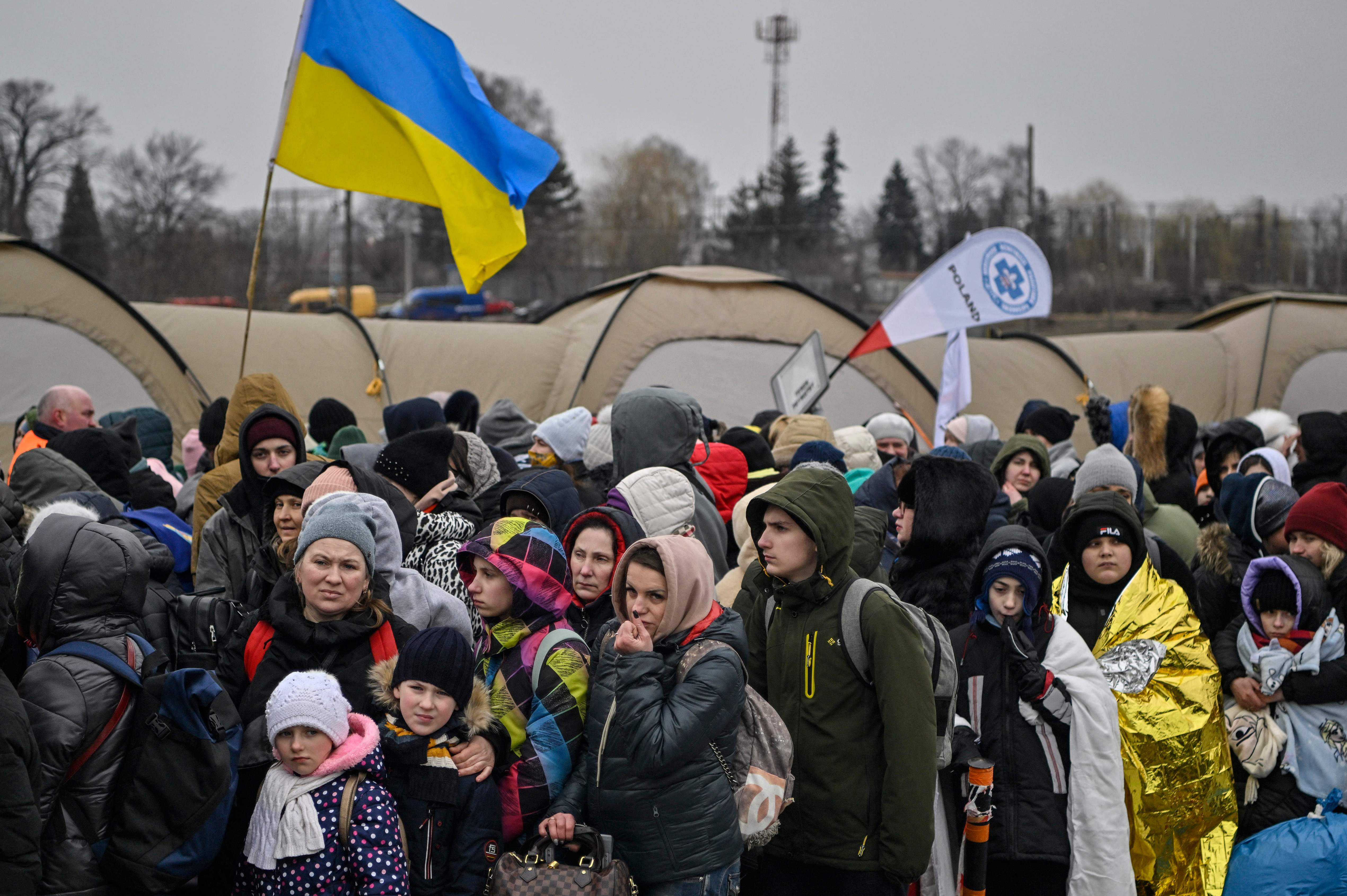 Hundreds of refugees stand in line as they wait to be transferred after crossing the Ukrainian border into Poland, at the Medyka border crossing in Poland, on March 7, 2022