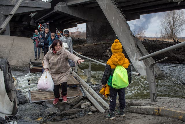 <p>Civilians cross a damaged bridge as they flee the city of Iprin near Kyiv, Ukraine</p>