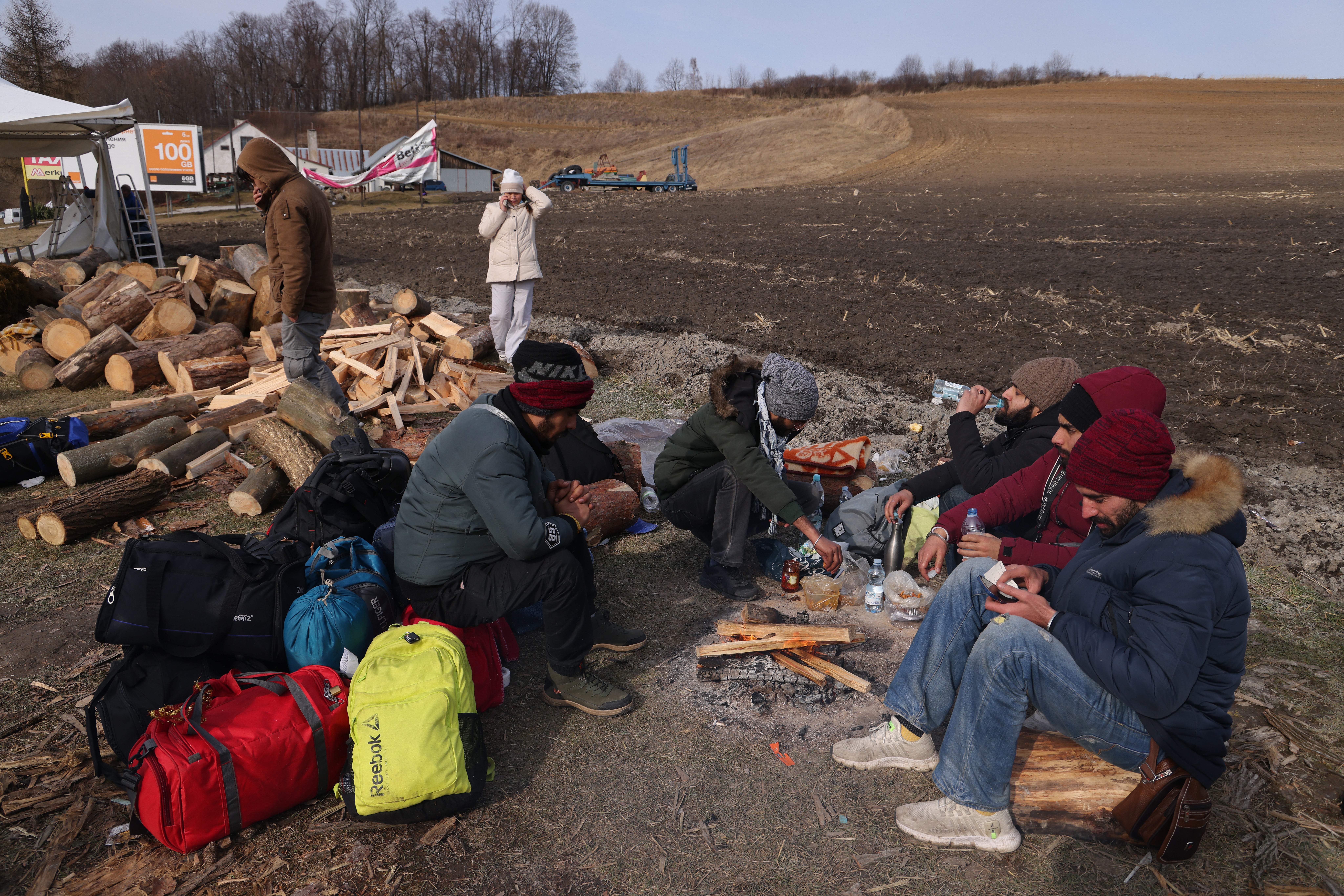 Indian and Nepalese students who had been studying at Poltava University of Economics and Trade in Ukraine prepare food around a campfire after arriving at the border