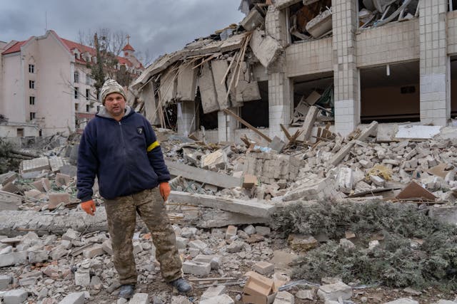 El cuidador Oleh se encuentra frente a los restos destruidos del edificio de la escuela principal en Zhytomyr.