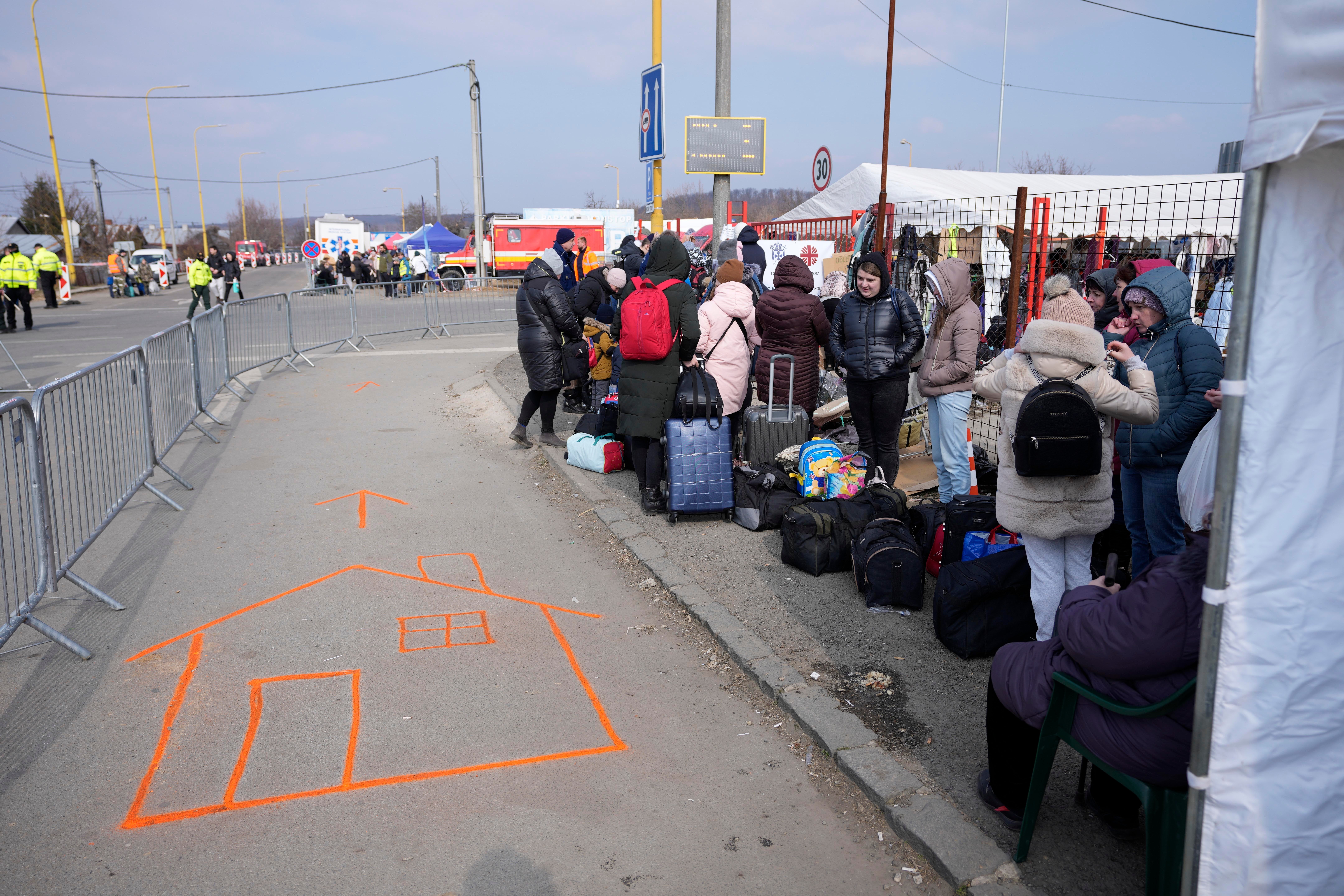 People fleeing from Ukraine queue as they with for a bus at the border in Vysne Nemecke, Slovakia (Darko Vojinovic/AP)