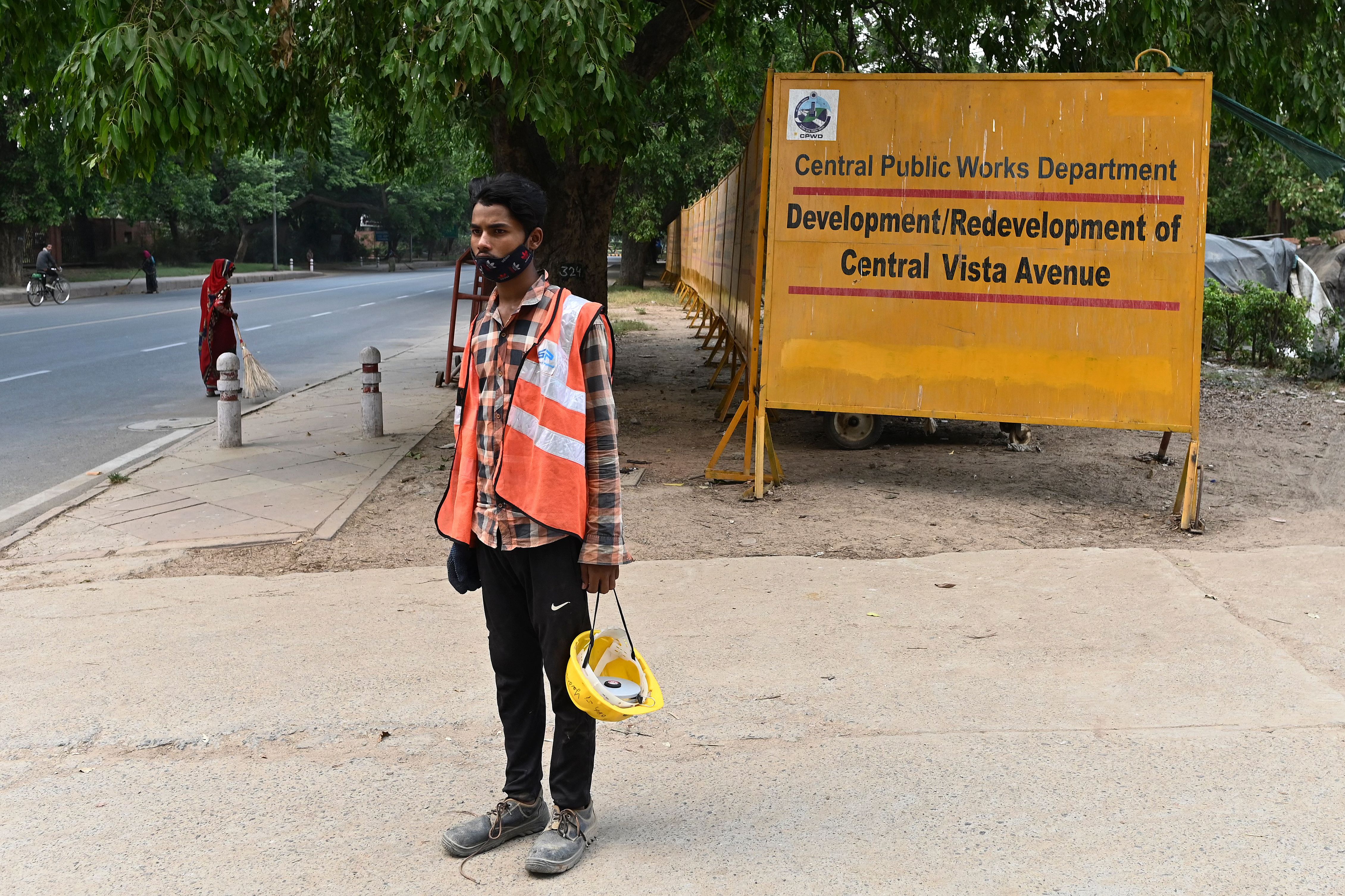 A worker stands at the site of a redevelopment work of the Central Vista Avenue by Central Public Works Department, along the Rajpath road in New Delhi
