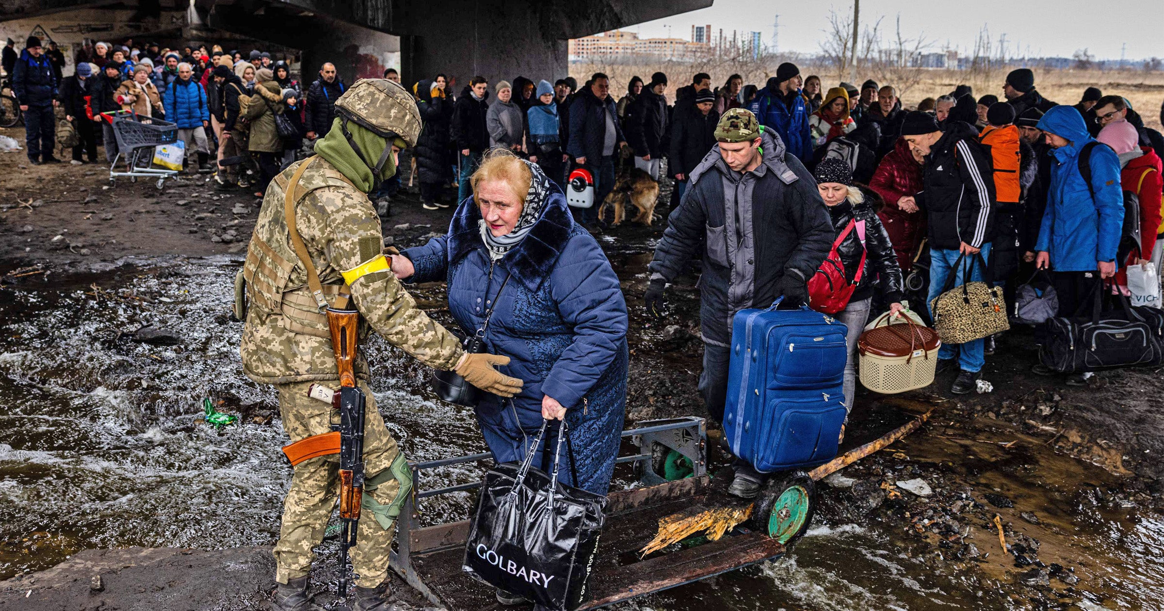 Ukrainian soldier helps evacuees as they flee Irpin, northwest of Kyiv