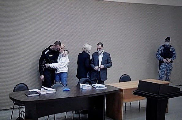 A photograph taken during a live broadcast of the court on the first day of Alexey Navalny’s new trial. He is pictured embracing his wife Yulia.