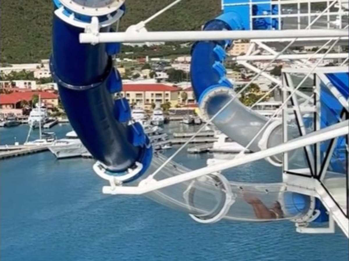 Woman gets stuck in clear cruise ship water slide overhanging sea