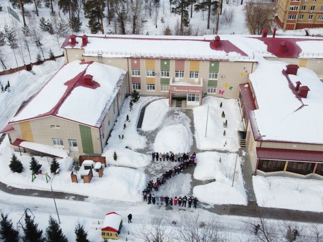 <p>Terminally ill children in Kazan, Russia, line up outside a cancer hospice in the shape of Z</p>