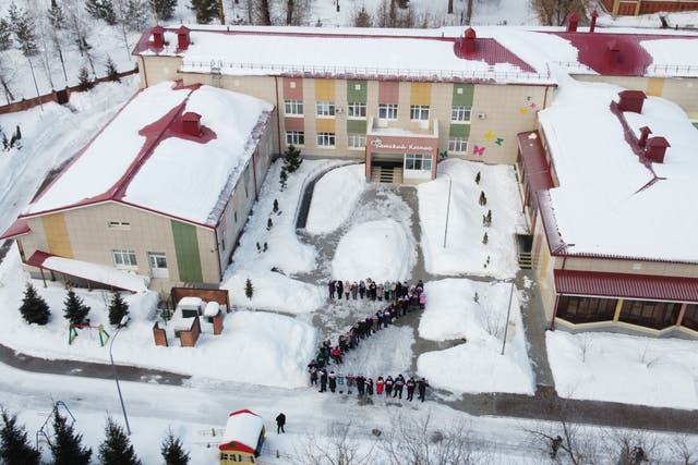 <p>Terminally ill children in Kazan, Russia, line up outside a cancer hospice in the shape of Z</p>