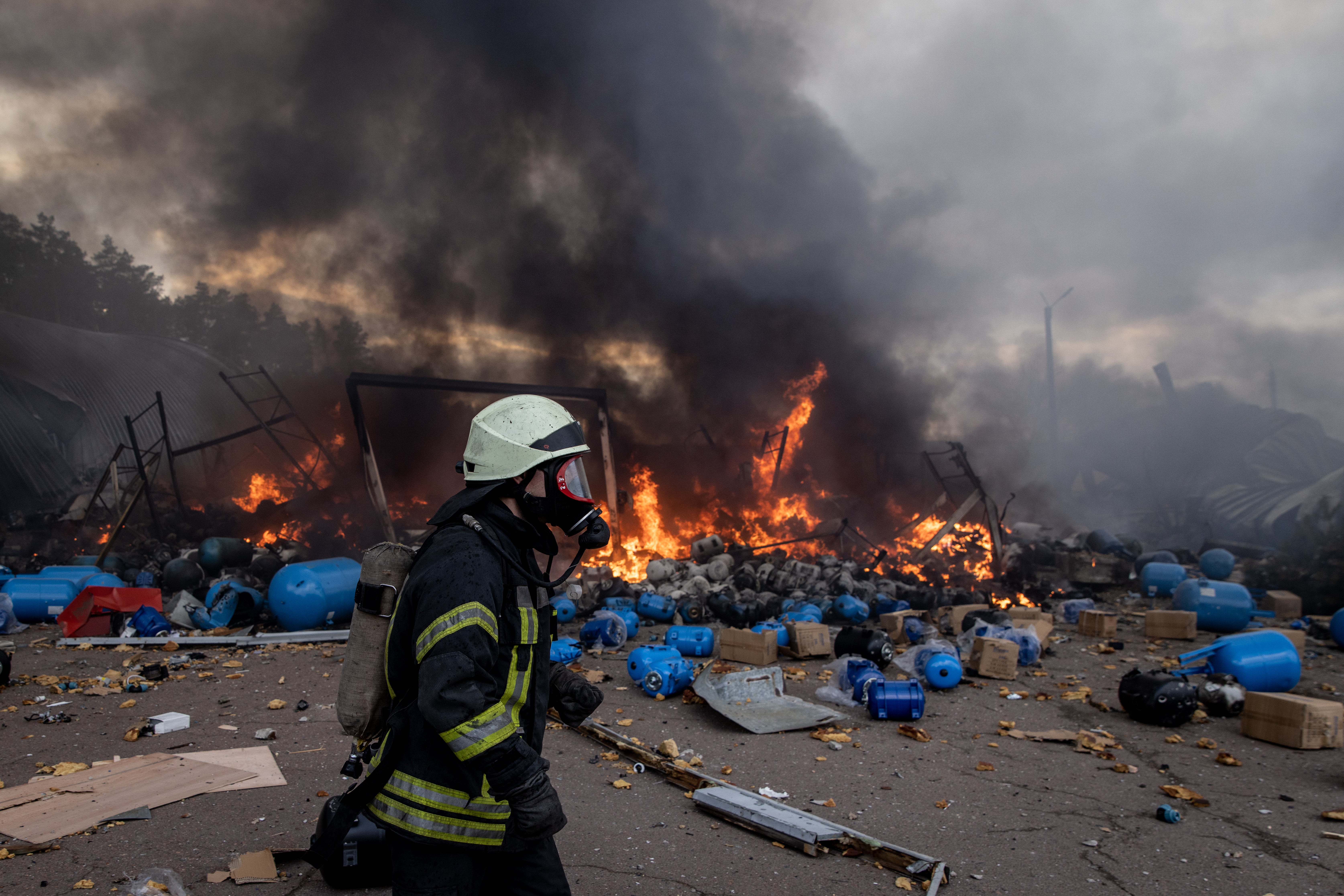 Firefighters try to extinguish a fire after a chemical warehouse was hit by Russian shelling in Ukraine