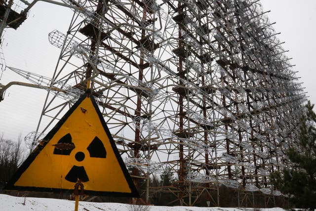 <p>A Soviet-era top secret object Duga, an over-the-horizon radar system once used as part of the Soviet missile defense early-warning radar network, seen behind a radioactivity sign in Chernobyl</p>