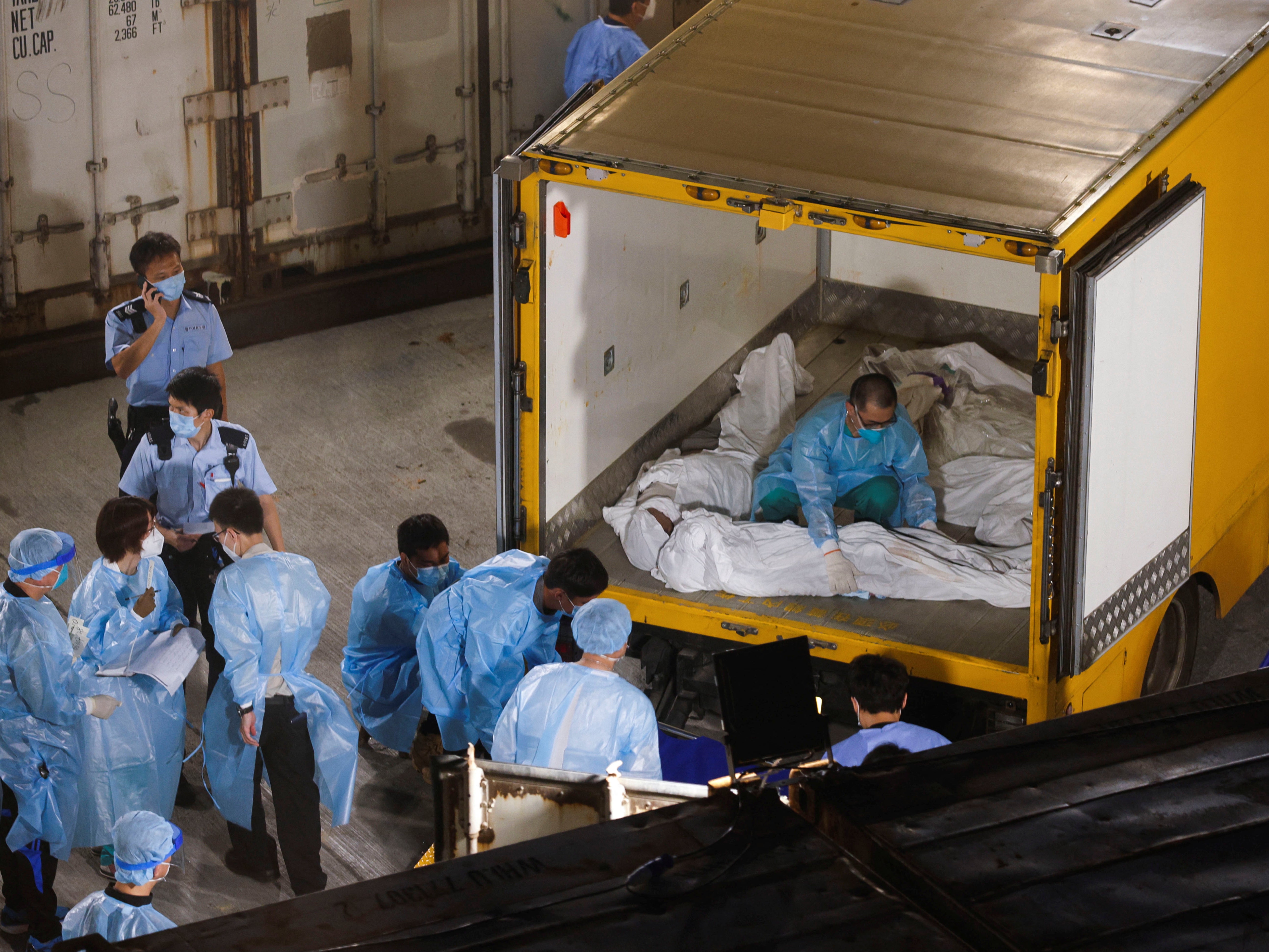 <p>Corpses are moved to a refrigerated container outside a funeral home as mortuaries run out of space amid the Covid disease outbreak in Hong Kong on 5 March</p>