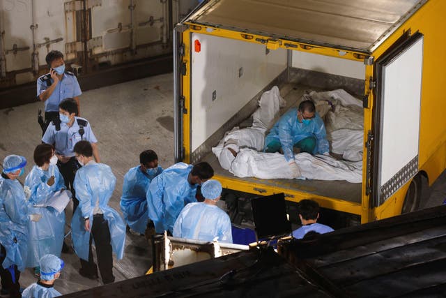 <p>Corpses are moved to a refrigerated container outside a funeral home as mortuaries run out of space amid the Covid disease outbreak in Hong Kong on 5 March</p>