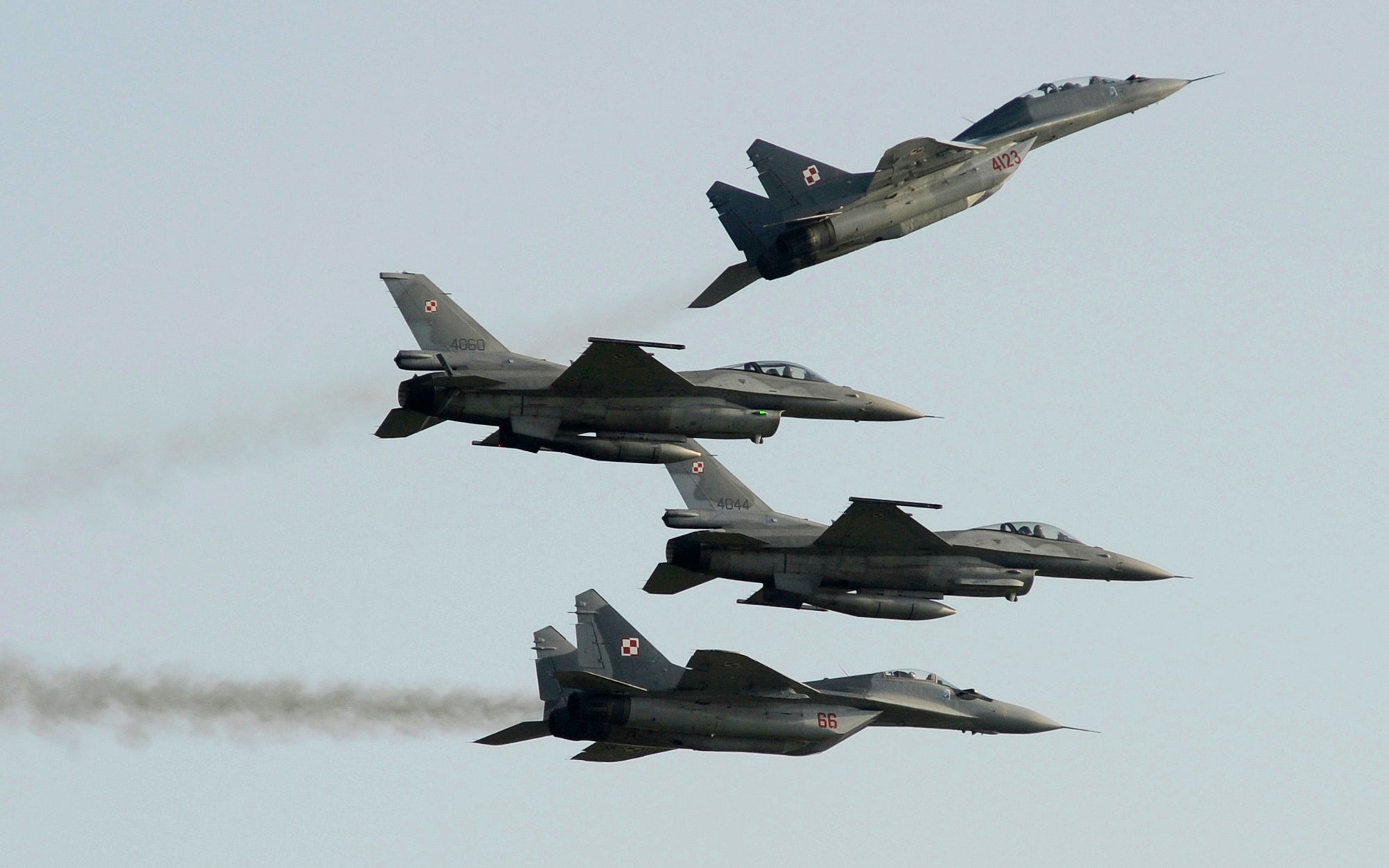 Two Polish Air Force Russian made Mig 29's fly above and below two Polish Air Force U.S. made F-16's fighter jets during an air show in Poland