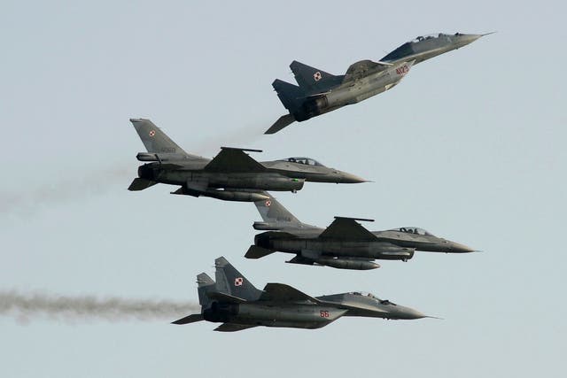 <p>Two Polish Air Force Russian made Mig 29's fly above and below two Polish Air Force U.S. made F-16's fighter jets during an air show in Poland </p>