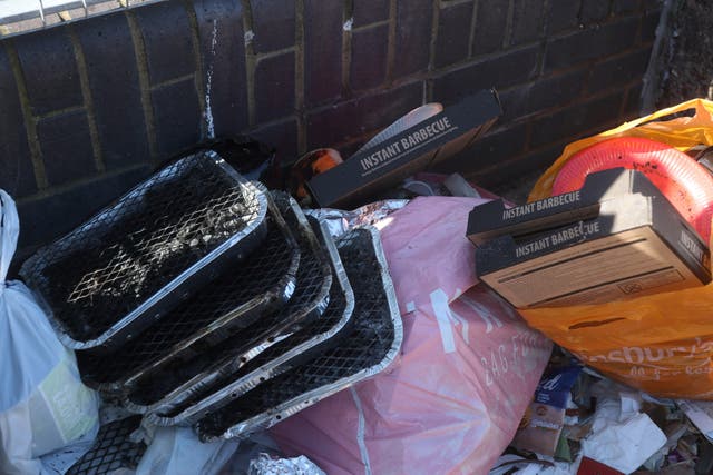A pile of used disposable instant barbecues next to a litter bin (PA)