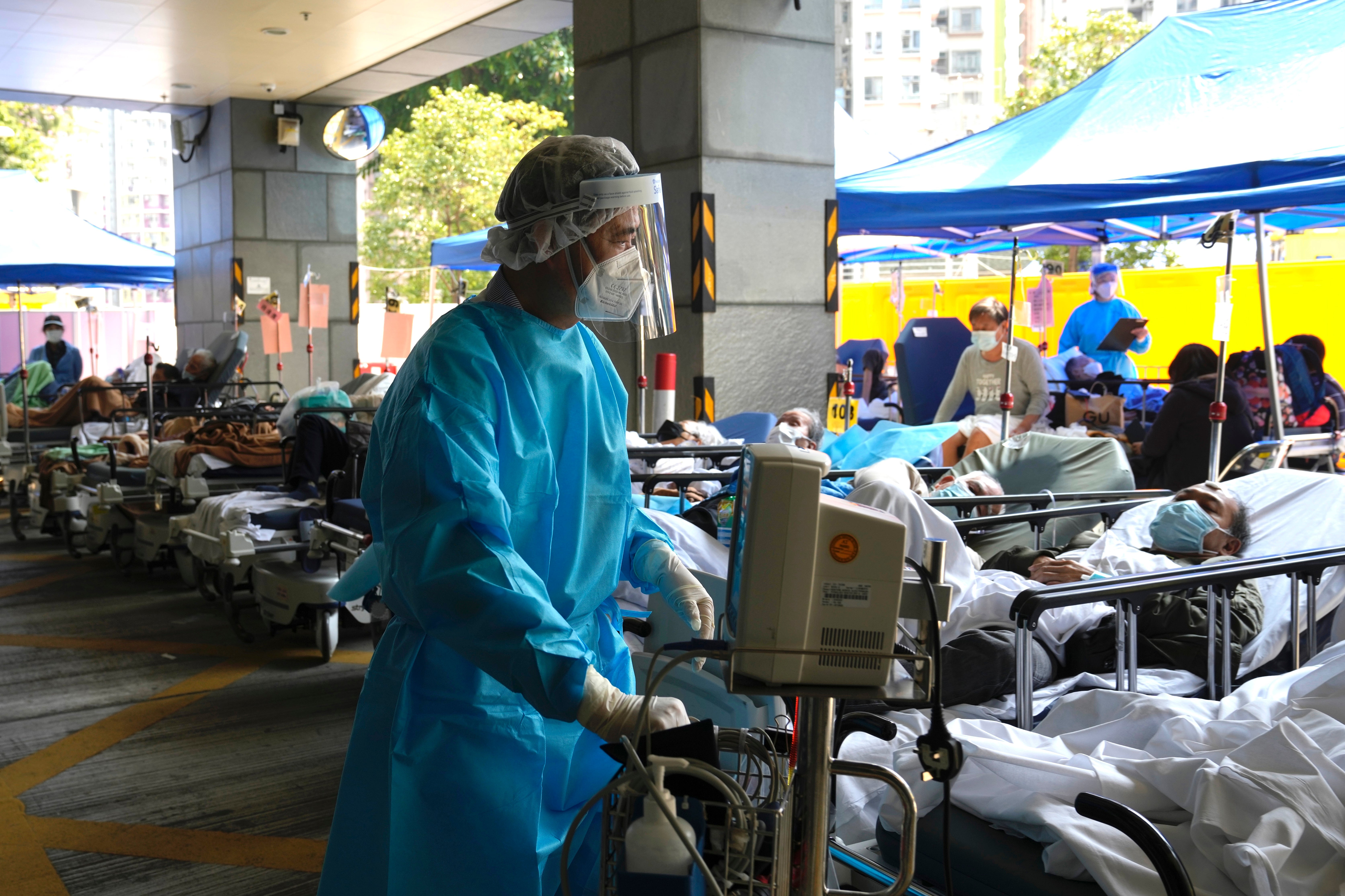Patients in hospital beds wait in a temporary holding area outside Caritas Medical Centre in Hong Kong