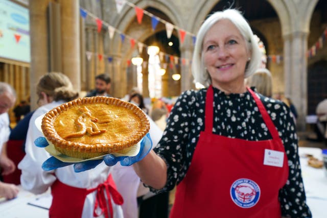 A judge holds a kangaroo pie entered for the British Pie Awards in Melton Mowbray (Jacob King/PA)