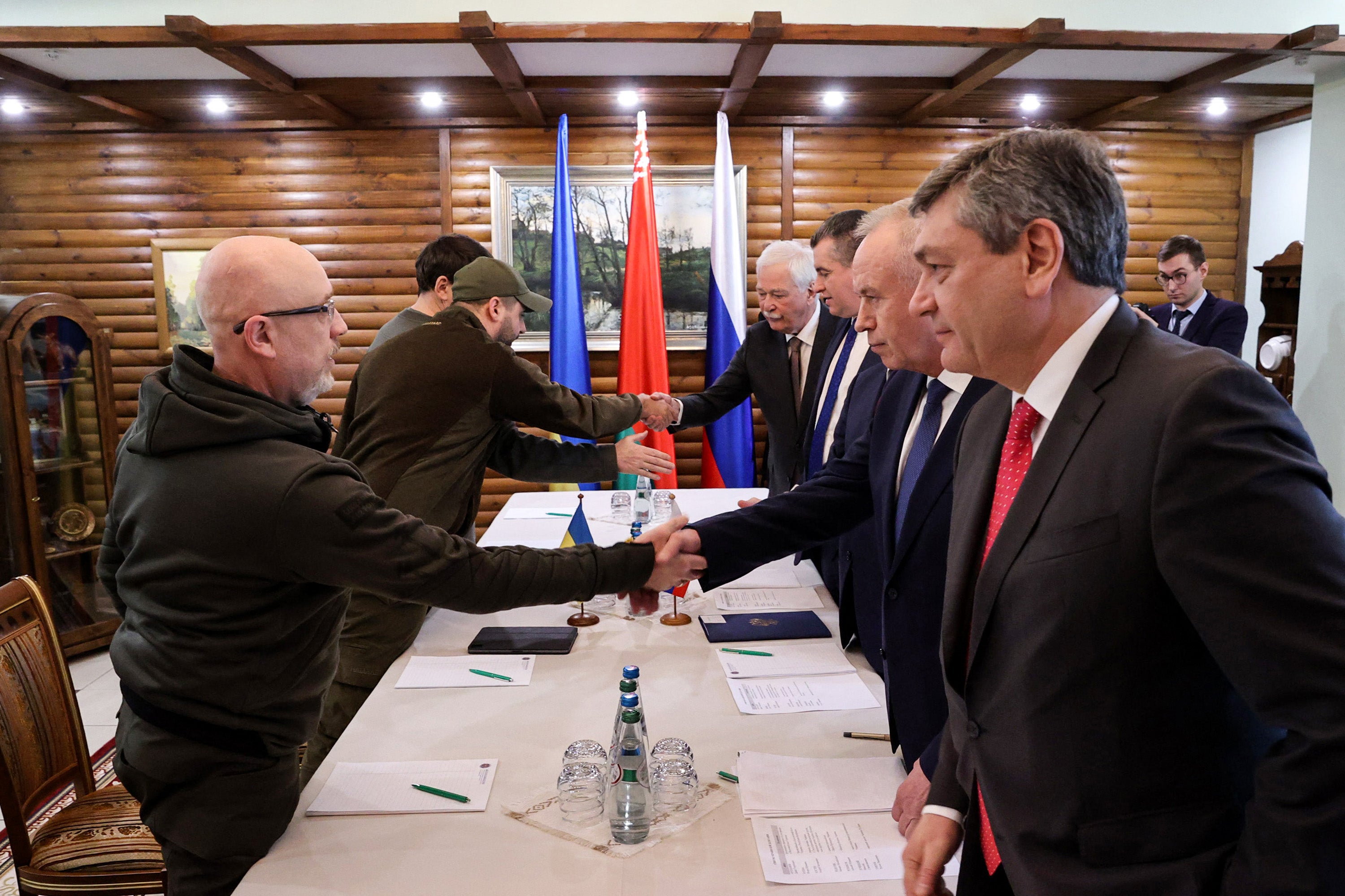 Ukrainian defence minister Oleksii Reznikov (L) shakes hands with Russian negotiators prior to the talks between delegations from Ukraine and Russia, 3 March 2022