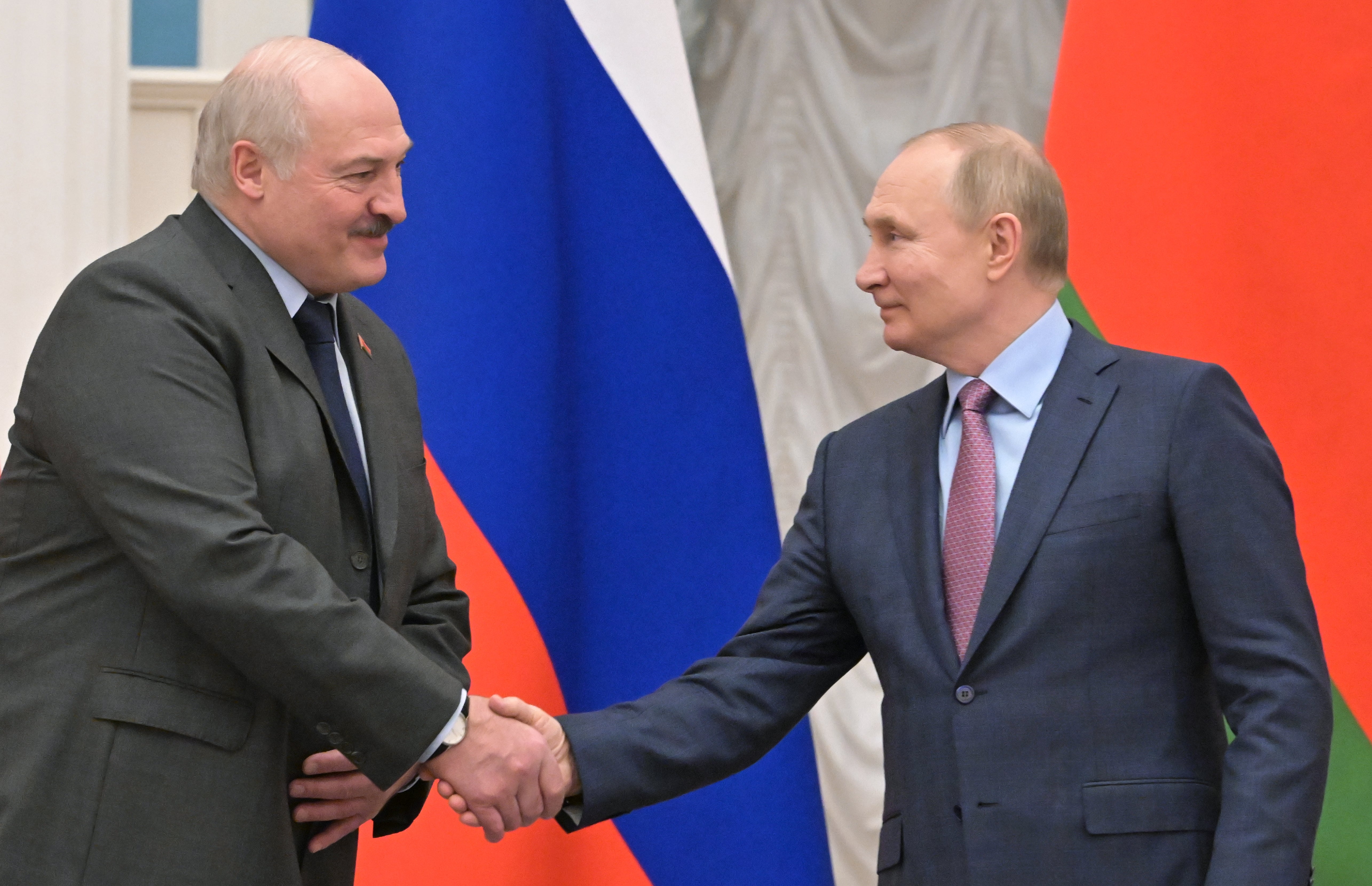 Belarusian president Alexander Lukashenko (L) and Vladimir Putin (R) shake hands at the Kremlin, 18 February 2022