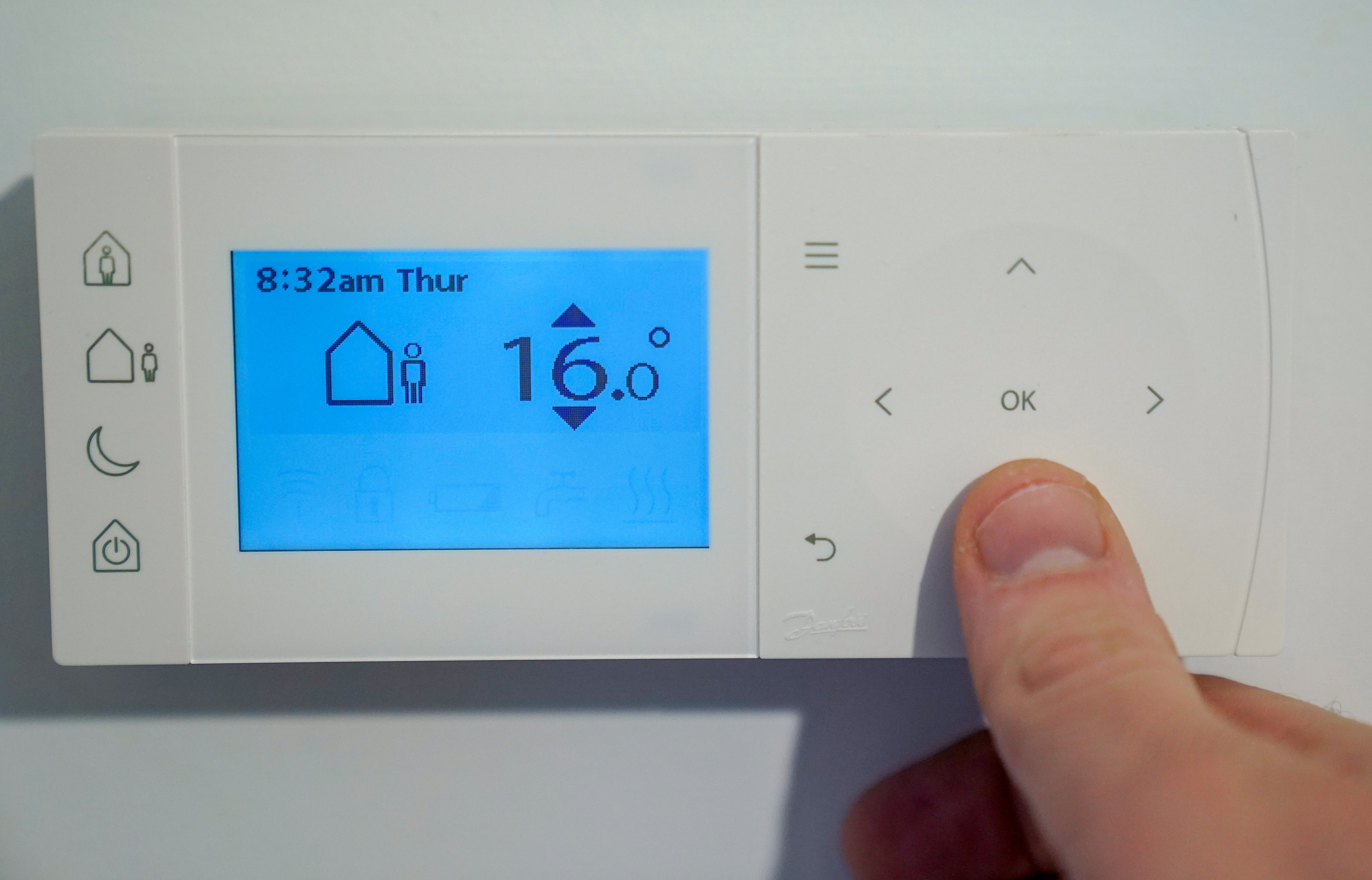 A homeowner turns down the temperature of a central heating thermostat in Basingstoke, Hampshire as energy prices rise (Andrew Matthews/PA)