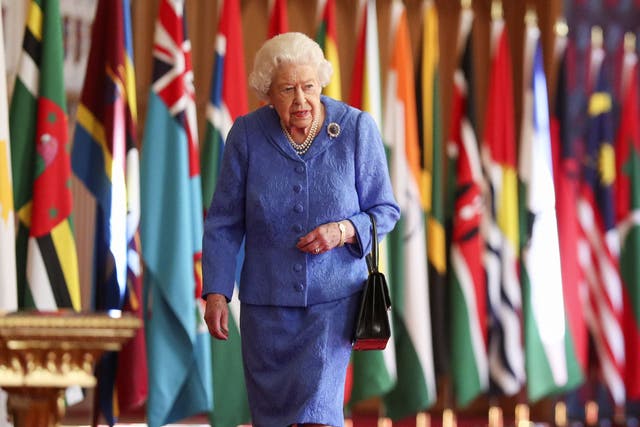 Queen Elizabeth II walks past Commonwealth flags in St George’s Hall at Windsor Castle , to mark Commonwealth Day 2021 (Steve Parsons/PA)