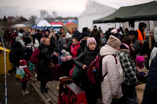 Refugiados esperan un autobús en Medyka, Polonia, después de cruzar desde Ucrania (Daniel Cole/AP)