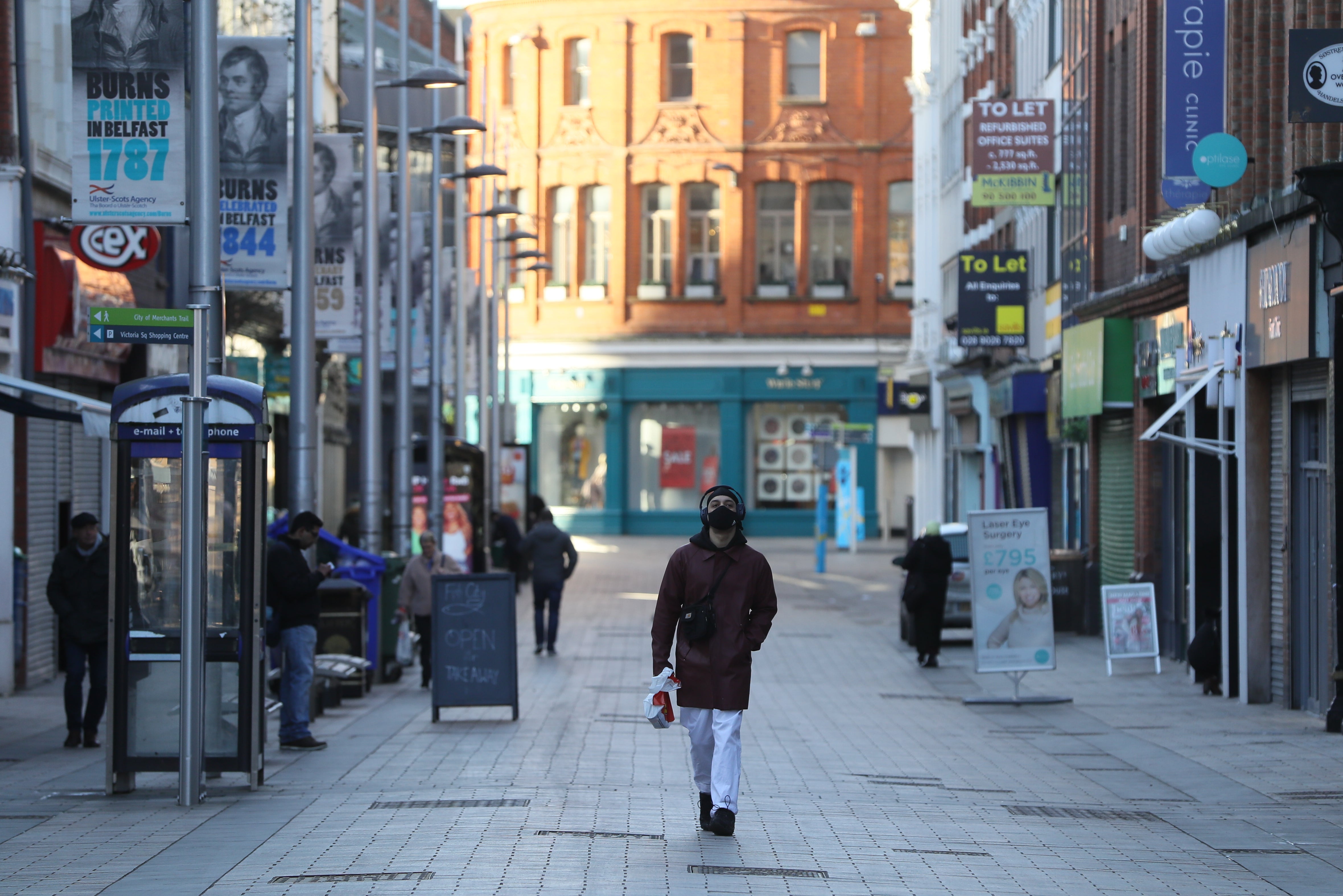 A man walks down a quiet street in Belfast city centre at the height of a Covid lockdown (PA)