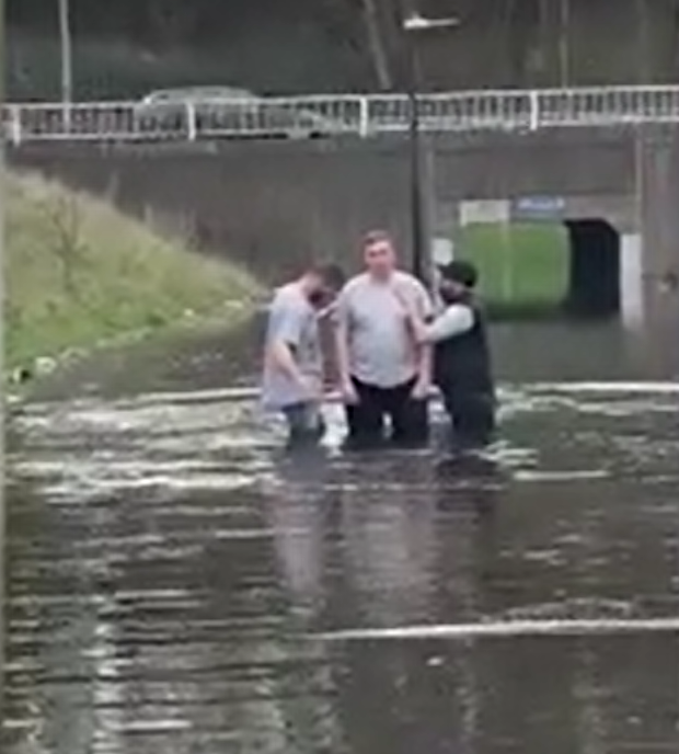 <p>A man being baptised in flooded Bristol roundabout </p>