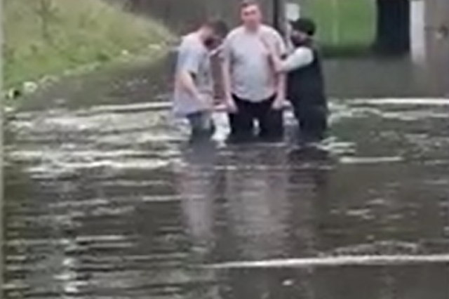 <p>A man being baptised in flooded Bristol roundabout </p>