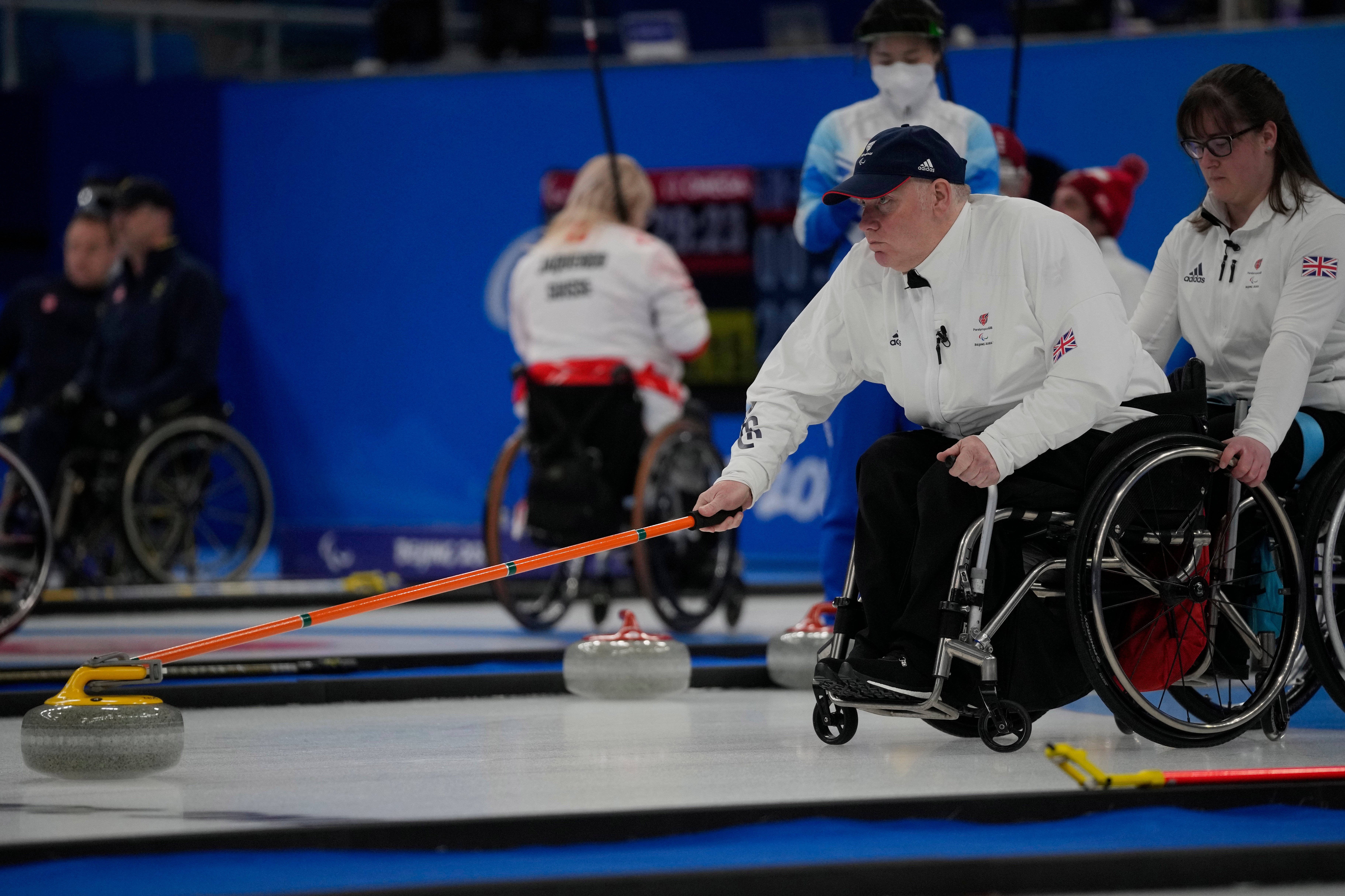 Britain’s Gary Smith pushes a stone as teammate Meggan Dawson-Farrell assists during their wheelchair curling tie against Dita Alangkara/AP)