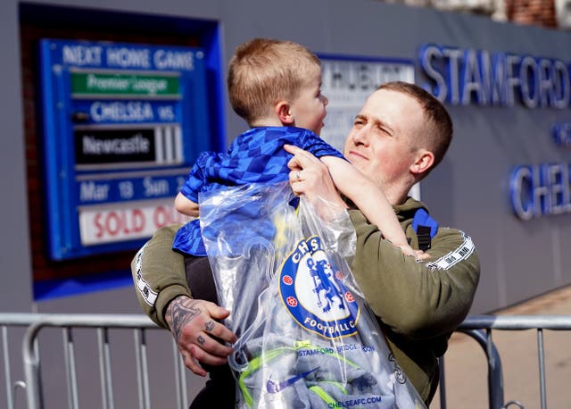 Martyn Hardiman with his son Peter, two, after purchasing the last club shirt before the store closed following the sanctioning of Roman Abramovich by the UK Government (Stefan Rousseau/PA)