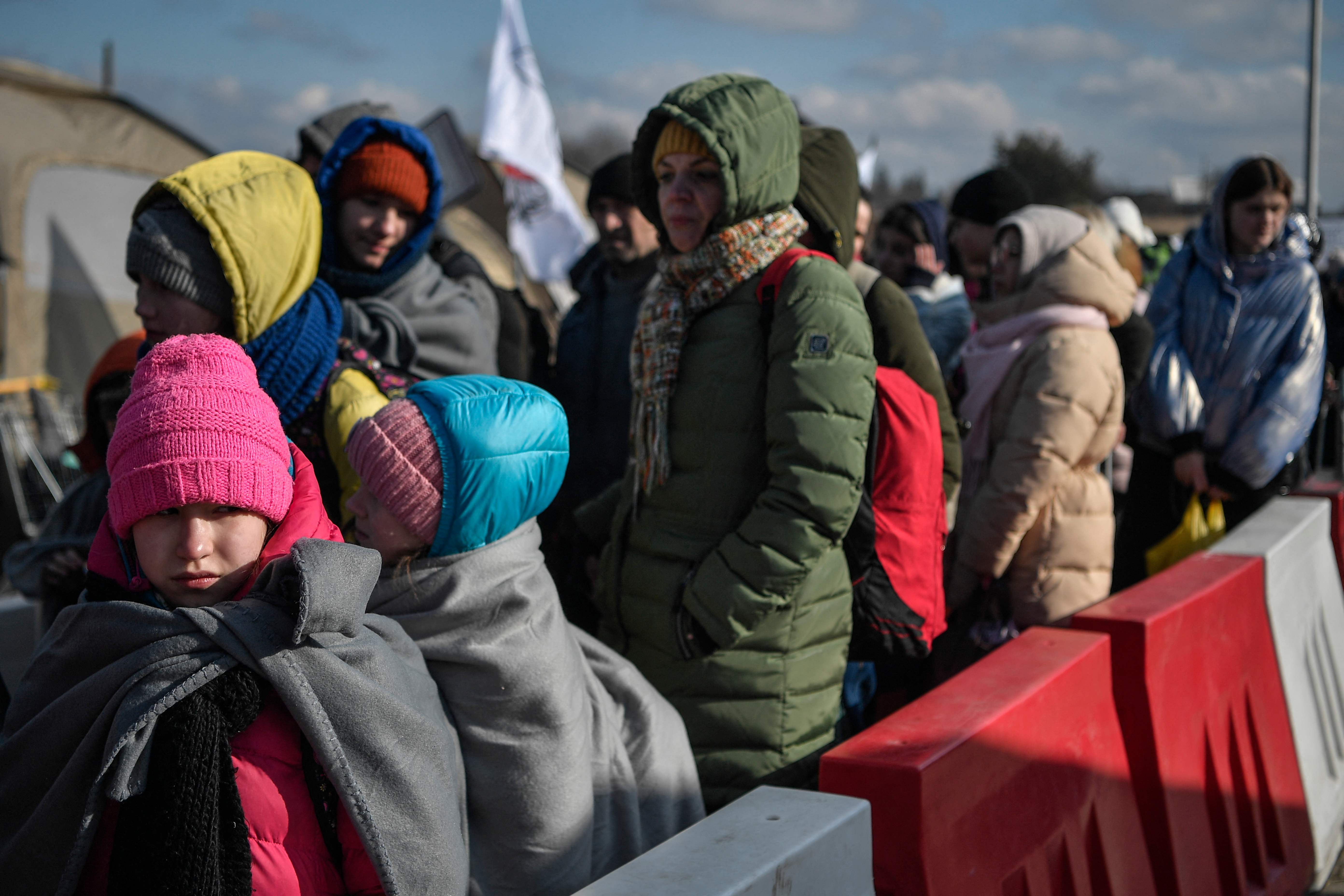 People wait to board buses after crossing the Ukrainian border into Poland, March 10, 2022