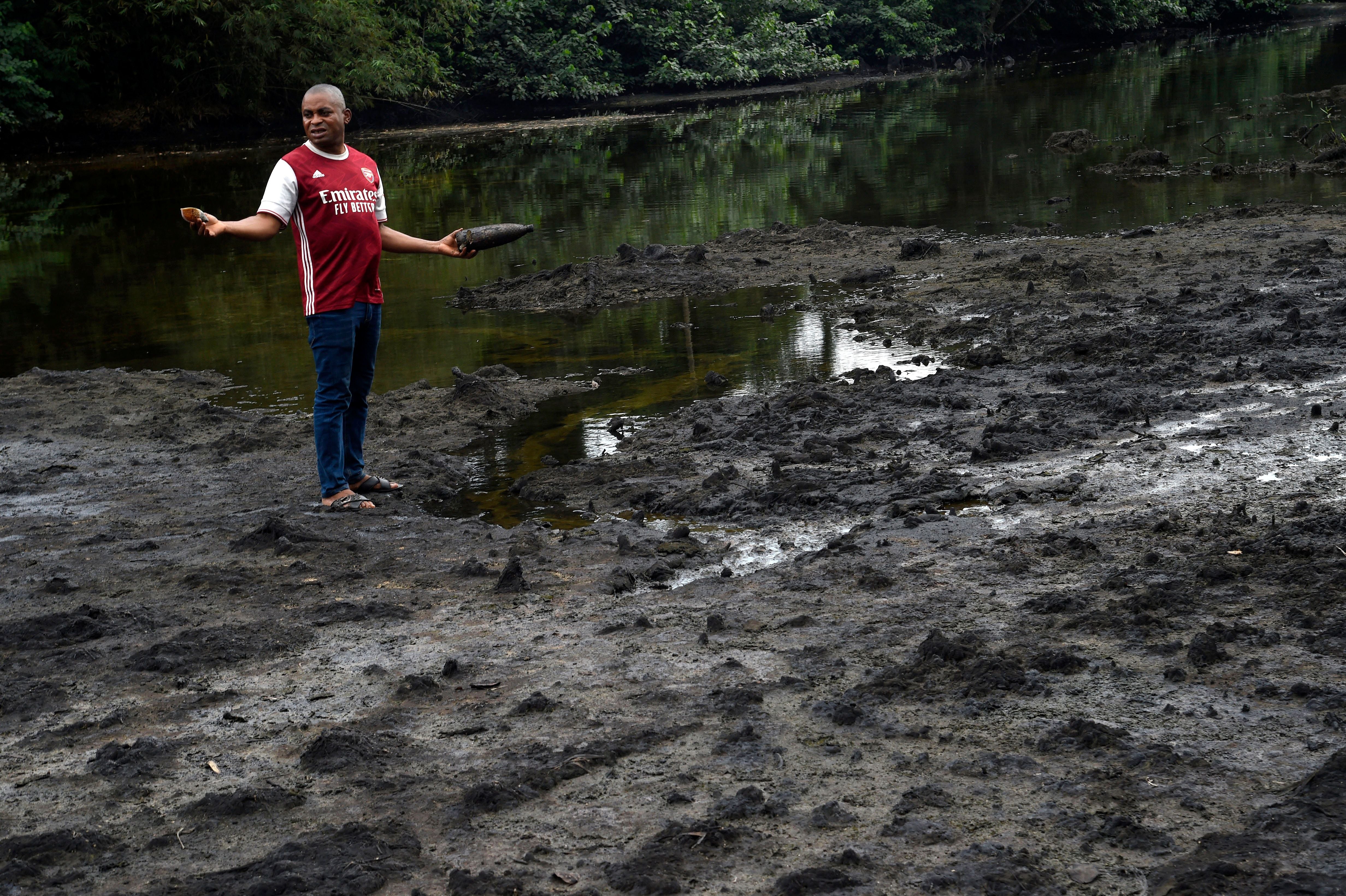 File: Resident stands on marshy shore of a river polluted by oil spills at B-Dere, Ogoniland in Rivers State, southern Nigeria, on 23 August 2021