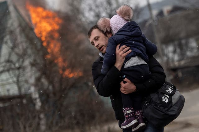 <p>A man and a child escape from the town of Irpin, after heavy shelling on the only escape route used by locals, while Russian troops advance towards the capital of Kyiv</p>