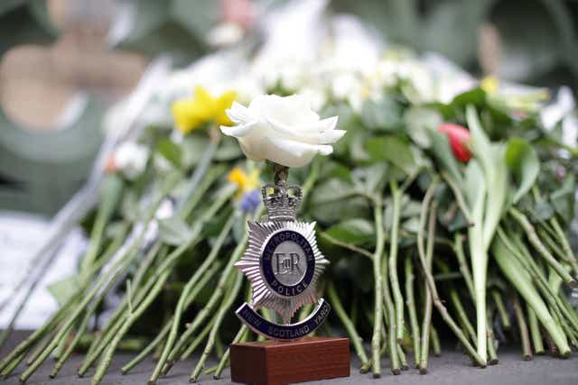 A police badge topped with a white rose is placed during a vigil on Westminster Bridge in London, one week since the Westminster terror attack in 2017 (PA)