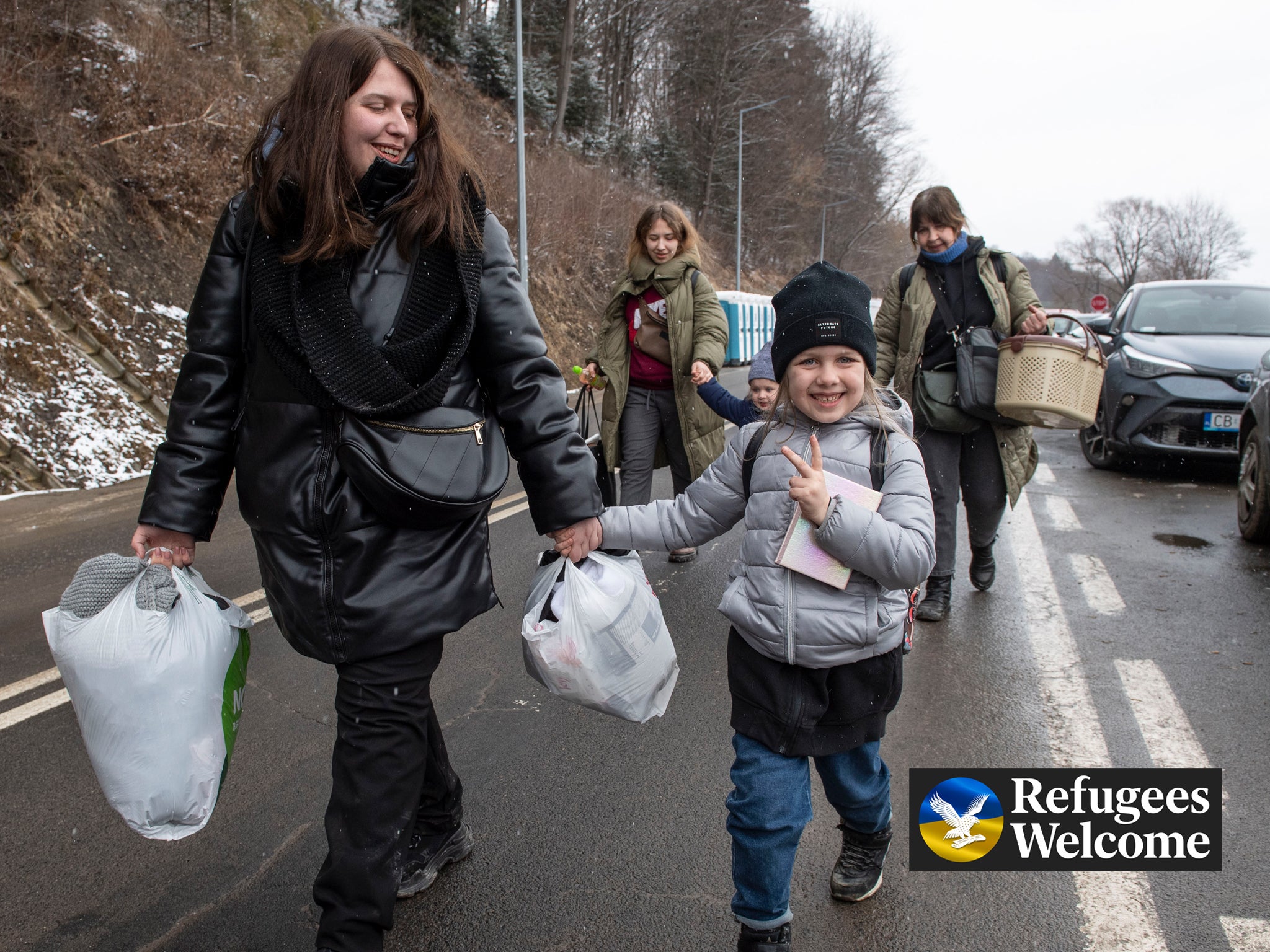 Ukrainian civilians who have fled the Russian invasion in Ukraine cross the border into Poland at Kroscienko