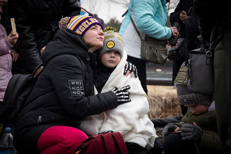 Families, mostly women and children, are waiting for hours in the cold to reach safety in Poland
