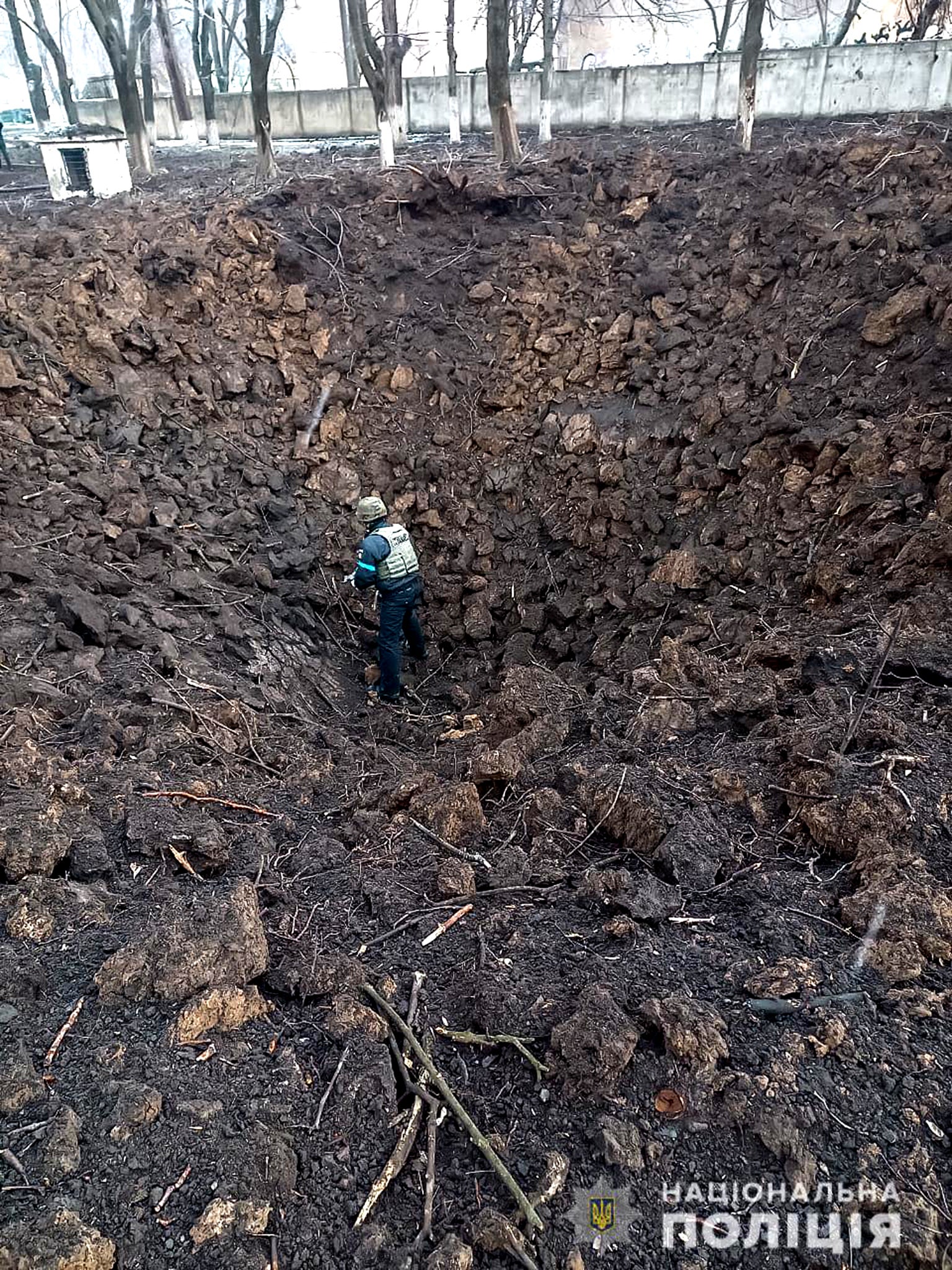 Police officer inspects a crater on the grounds of the Mariupol maternity hospital hit by an airstrike on Wednesday