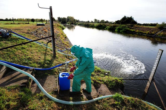 An Environment Agency worker treating the River Trent at Yoxall, Staffordshire, after it was contaminated with untreated sewage and cyanide (Rui Vieira/PA)