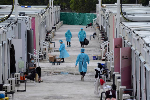 <p>Healthcare personnel work at the makeshift Covid-19 isolation facilities in the San Tin area of Hong Kong on 11 March</p>