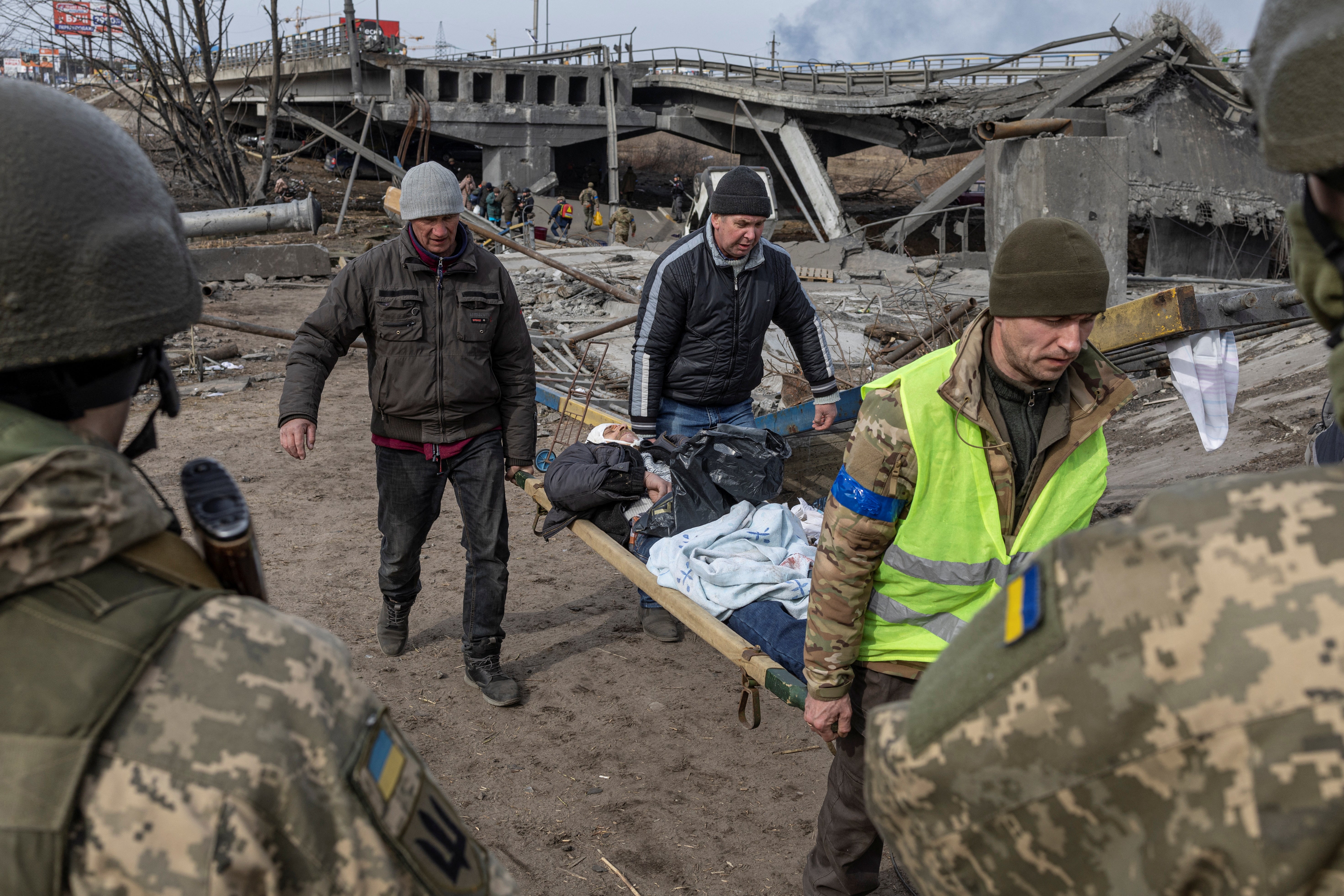 A wounded man is evacuated in the town of Irpin, outside Kyiv, on 12 March