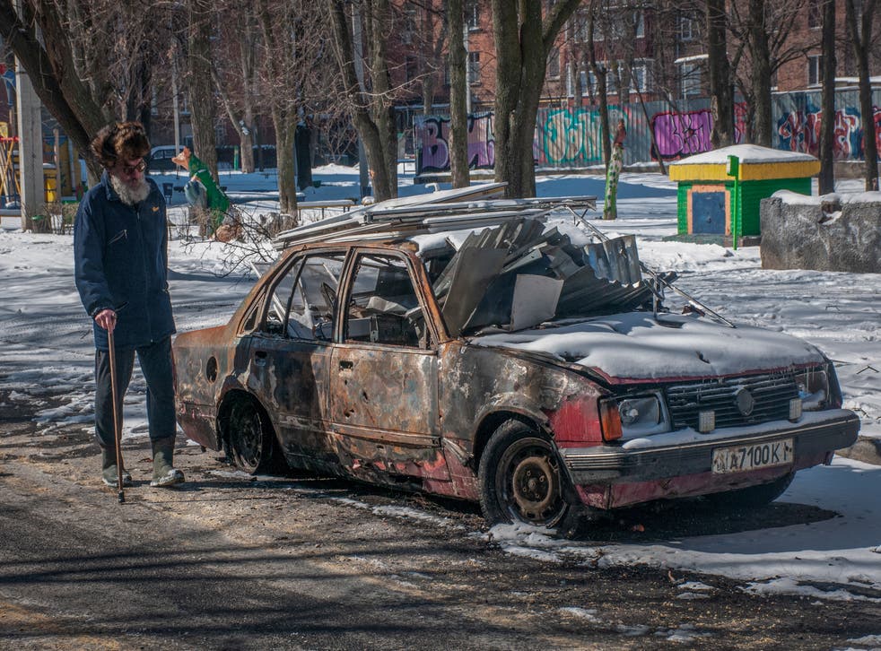 <p>A man walks near a burned car in downtown of Kharkiv, Ukraine</p>