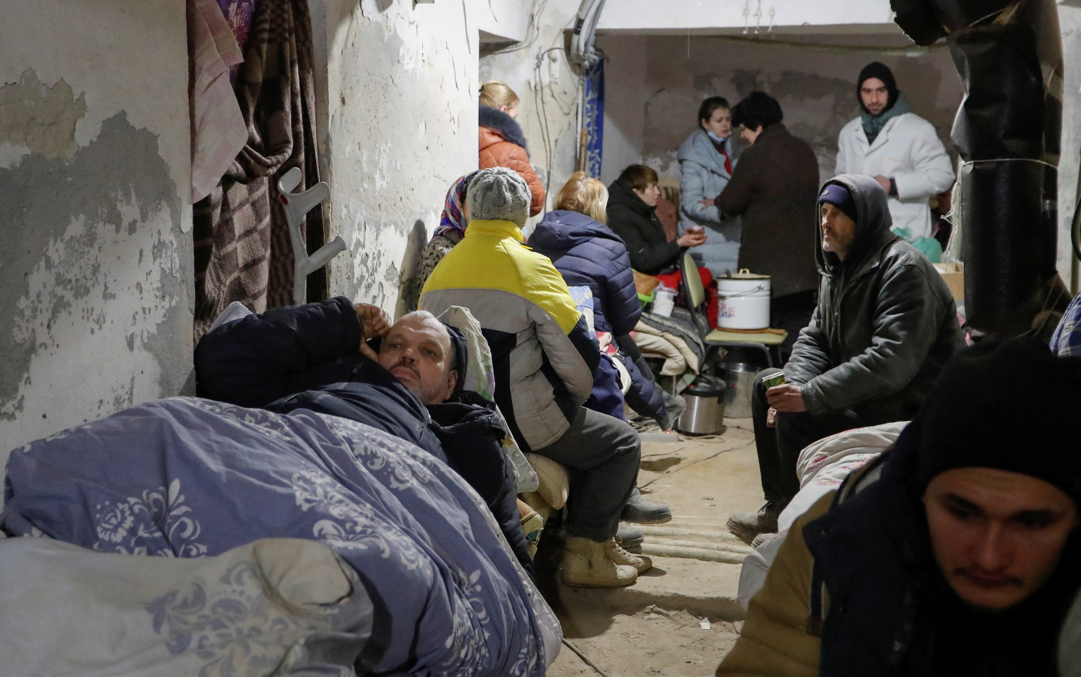 People gather in the basement of a local hospital, which was damaged during Ukraine-Russia conflict in the separatist-controlled town of Volnovakha in the Donetsk region