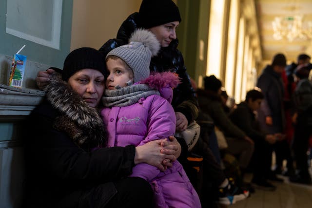 Ukrainian refugee Elena, left, hugs her five-year old granddaughter Christina, as they wait in Poland for the train to Warsaw (Petros Giannakouris/AP)