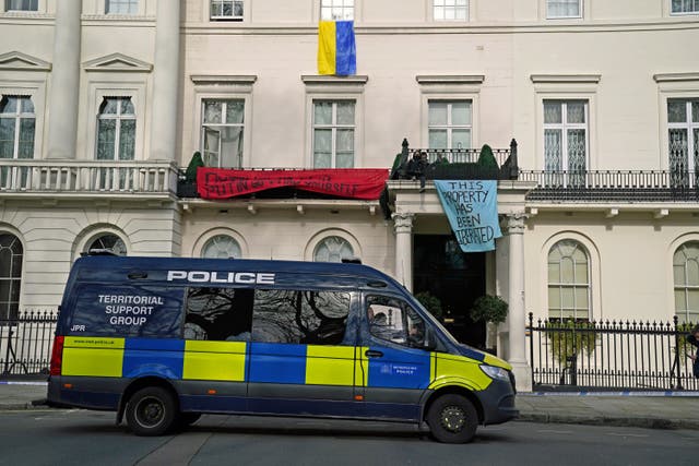 Officers from the Metropolitan Police Territorial Support Group watch over a group of squatters occupying a mansion belonging to Russian oligarch Oleg Deripaska in central London (Jonathan Brady/PA)