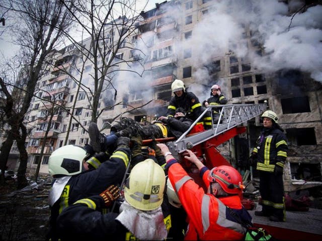 Los bomberos evacuan a un hombre de un edificio de apartamentos afectado por bombardeos en Kiev